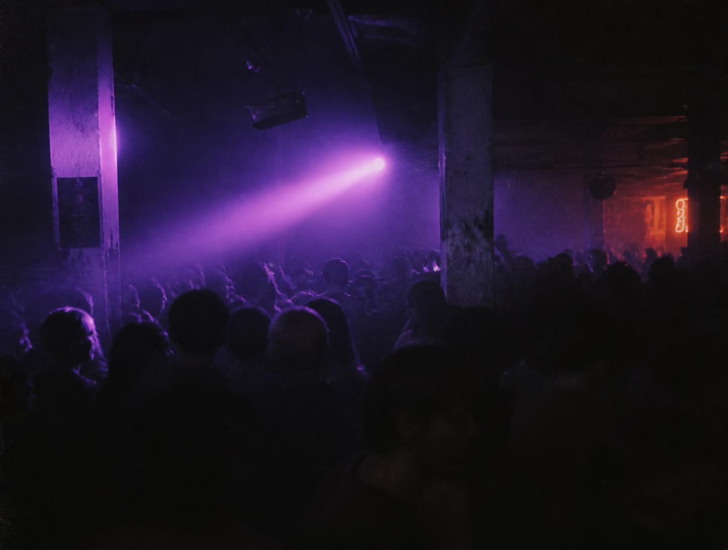 Tanzfläche im Nebel mit violettem Lichtstrahl